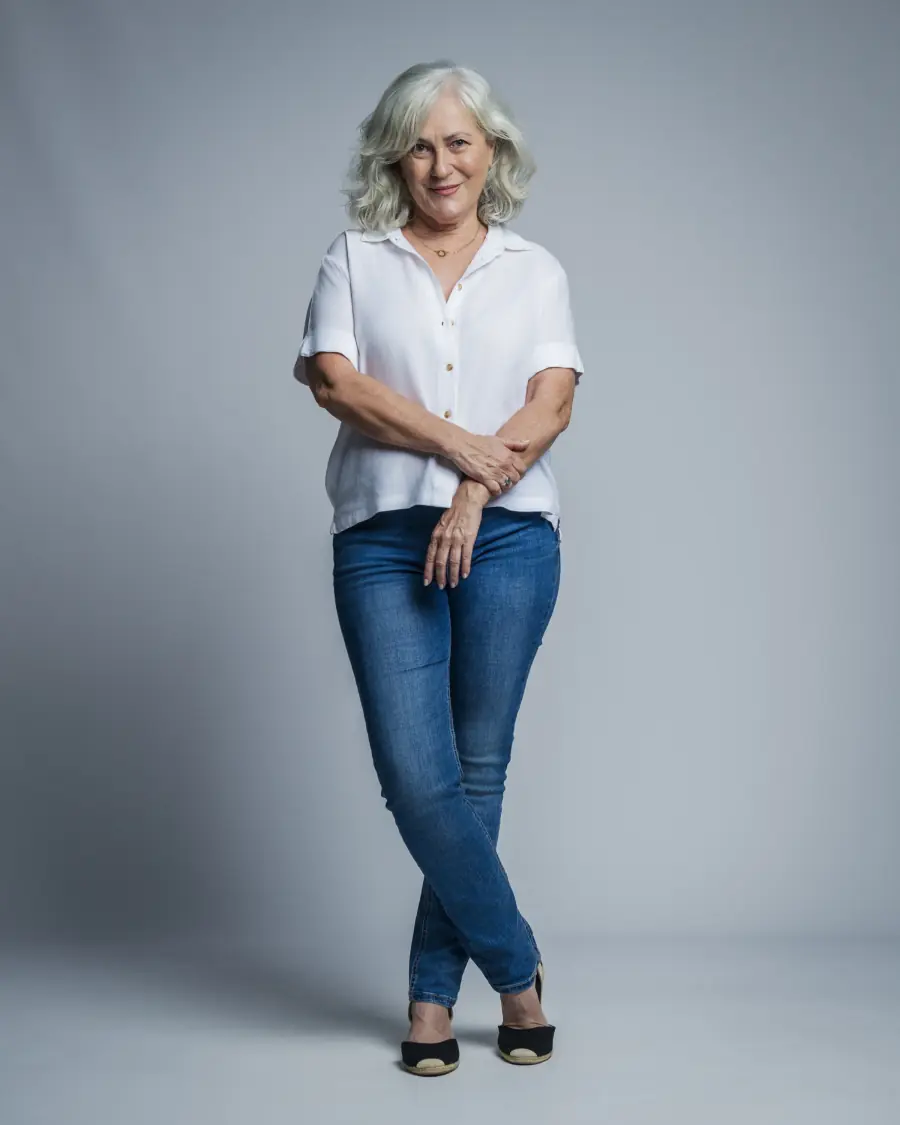 Pilar Blanco, actriz, de pie con camisa blanca y vaqueros